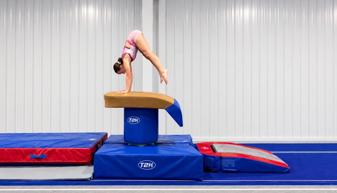 Gymnast performing a vault over the vault table in the React TGC gymnasium